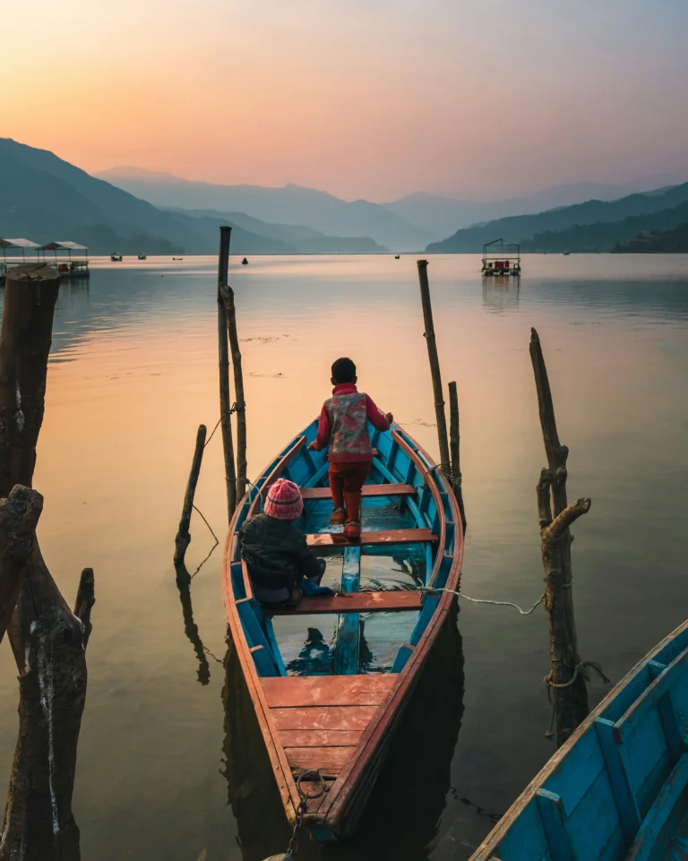 Pokhara, Nepal; The Pulse of Annapurna Region Trekking 1 Tranquil Phewa Lake in Pokhara, Nepal, reflecting the surrounding hills and colorful boats.