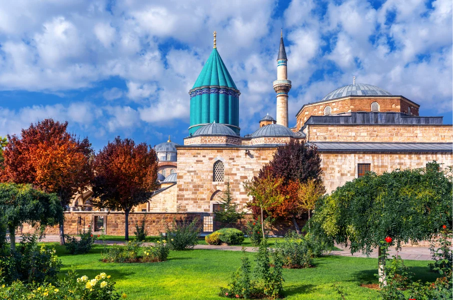 Majestic tomb of Rumi in Konya, Turkey, surrounded by vibrant turquoise tiles and Islamic calligraphy, symbolizing Sufi spirituality and the poet's legacy